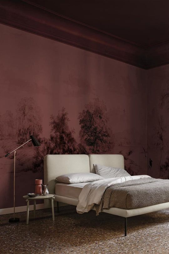 a bed sitting in a bedroom next to a wall with trees painted on the walls