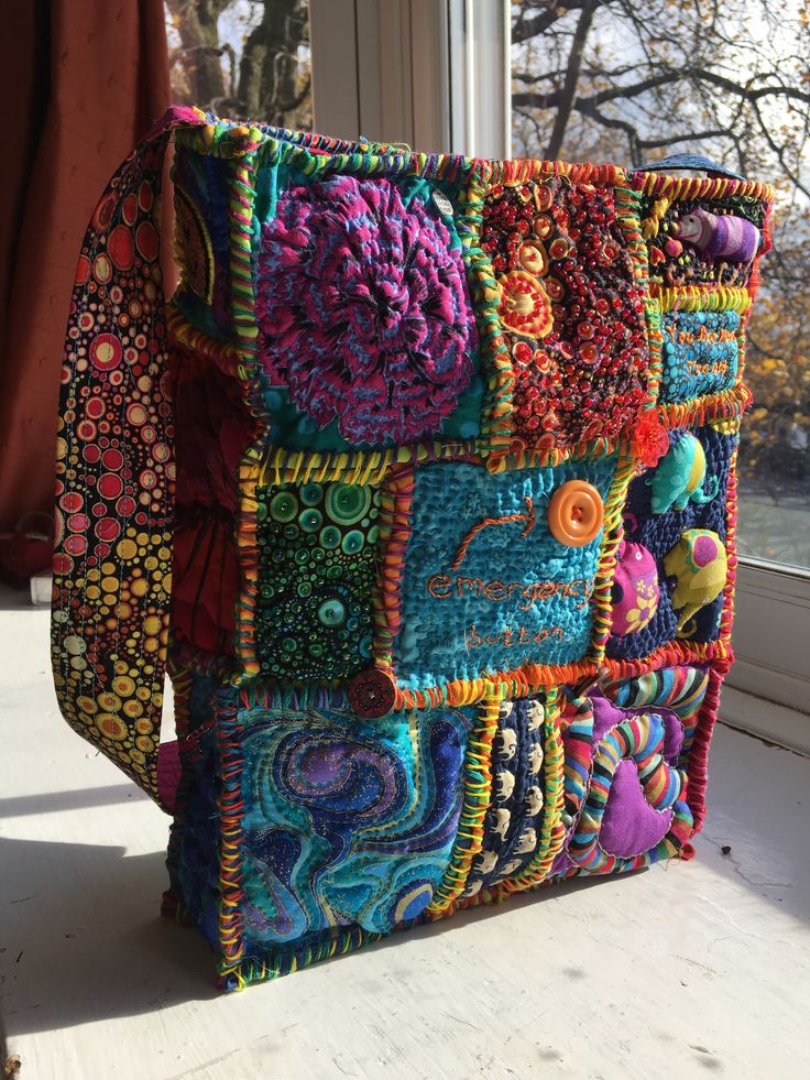 a multicolored purse sitting on top of a window sill