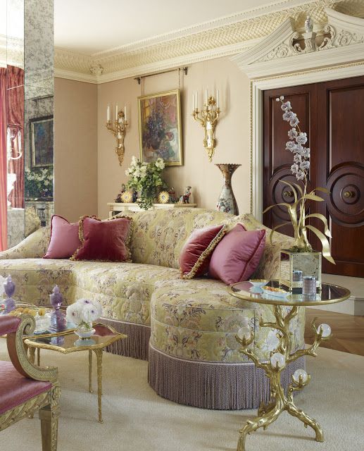 a living room filled with lots of furniture and red curtains on the window sill