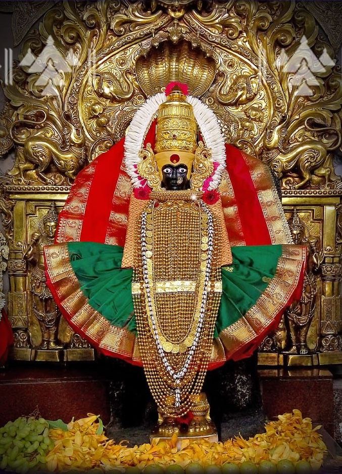 the statue is decorated with gold and green colors on it's face, surrounded by other decorations