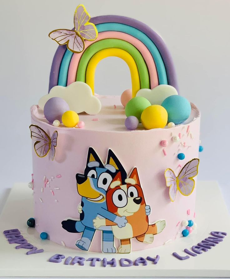 a birthday cake decorated with cartoon characters and rainbows