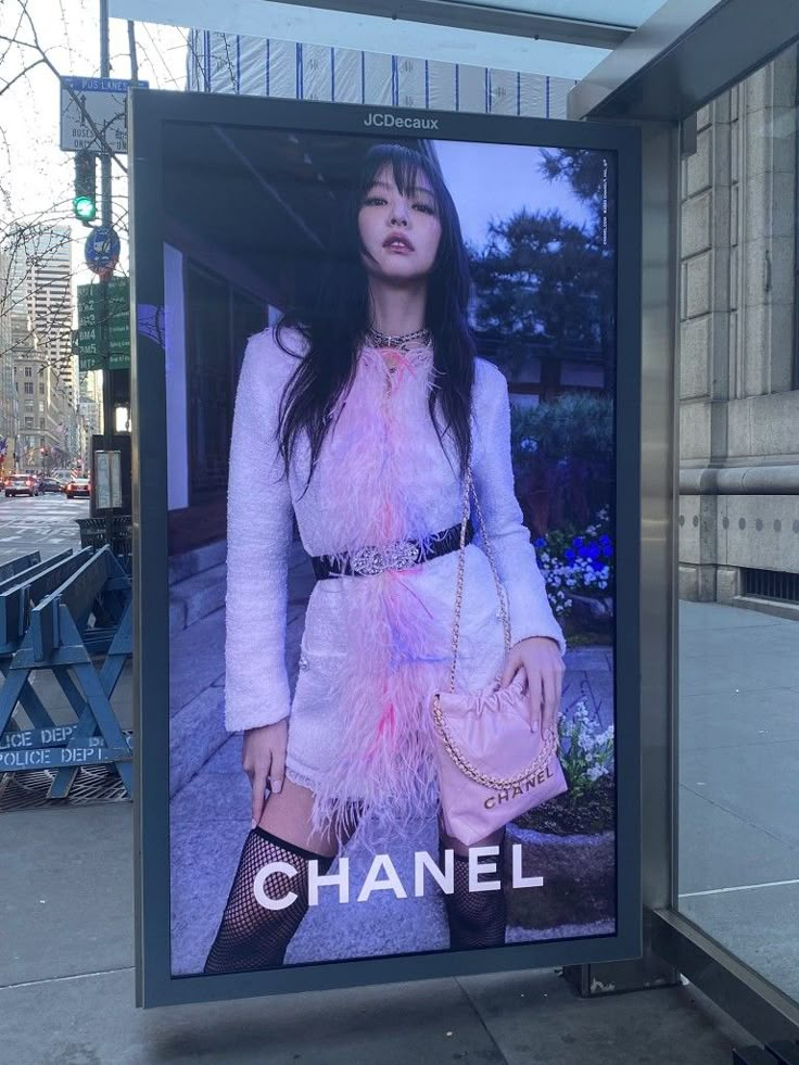 a billboard advertises chanel on the sidewalk