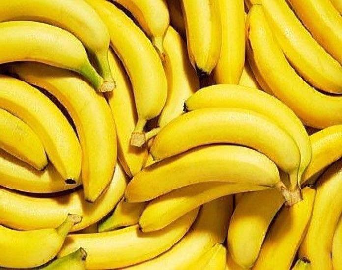 several bunches of bananas are piled up in a closeup view to show their ripeness