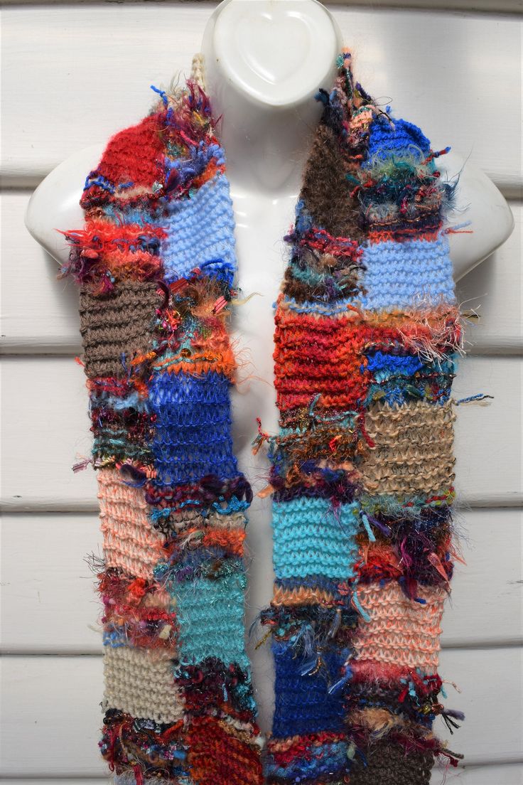 a white mannequin wearing a multicolored scarf