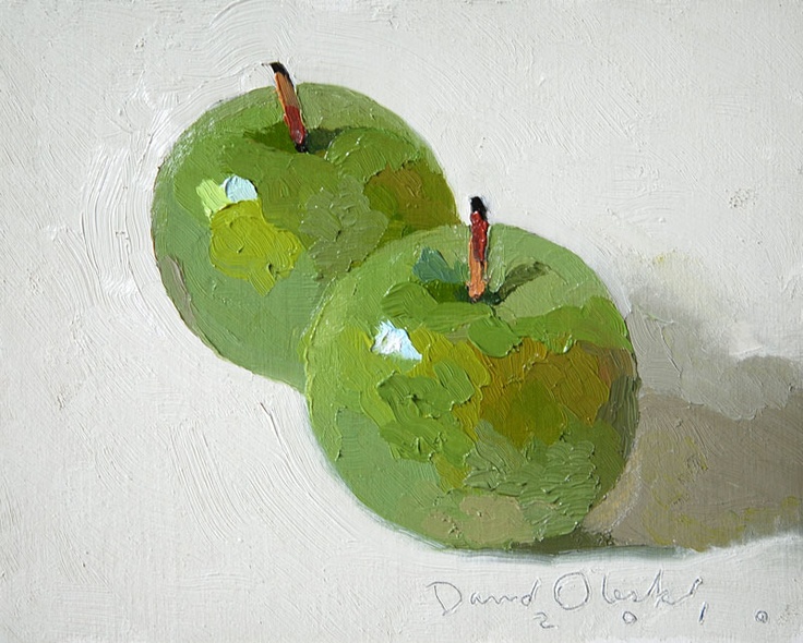 two green apples sitting side by side on a white surface, with one painted red and the other green