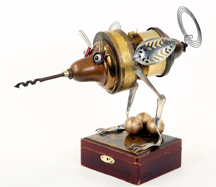 a metal figurine of a mouse with a key in its mouth on top of a wooden box