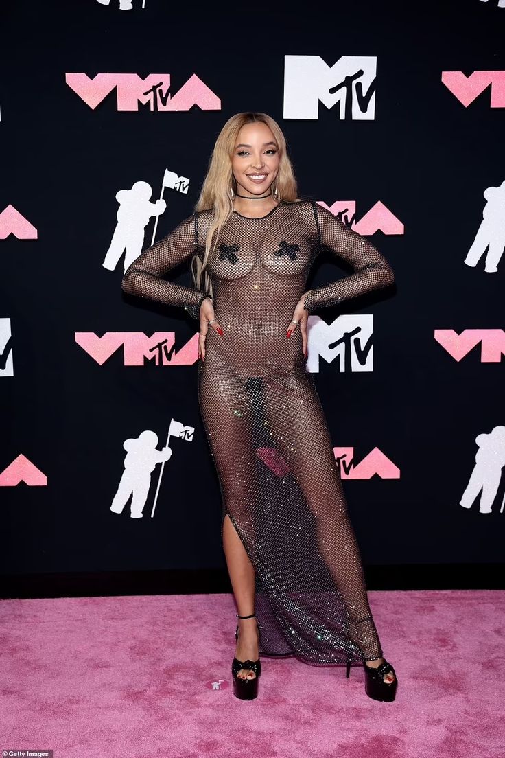 the singer is wearing a sheer mesh dress and black heels at the vmas awards