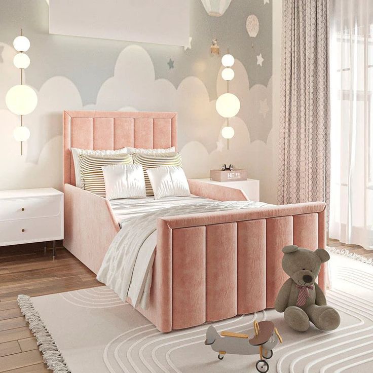 a teddy bear sitting on the floor in front of a bed with pink velvet headboard and foot board