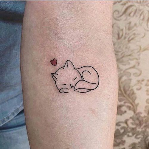 a small tattoo on the arm of a person with a cat and heart in it