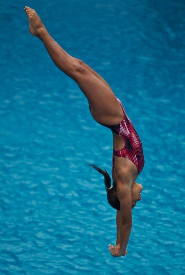 a woman diving into the water with her feet in the air