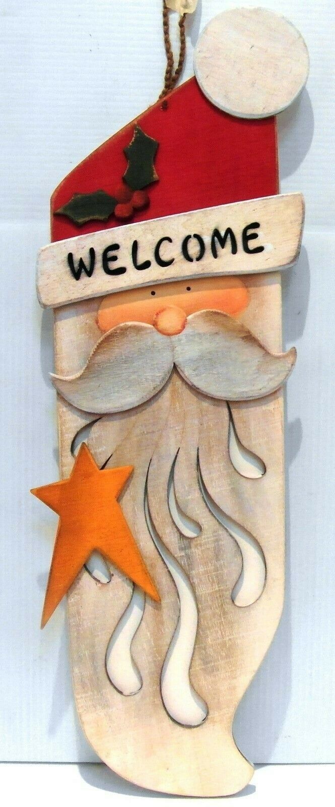 a wooden sign that says welcome with a santa clause on it's hat and star