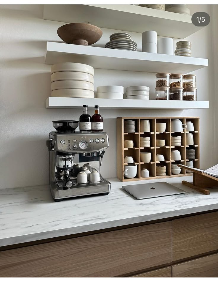 an espresso machine sitting on top of a counter next to plates and bowls