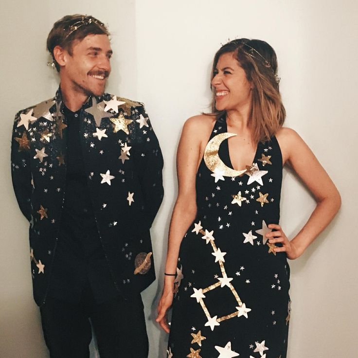 two people standing next to each other in front of a wall with stars on it