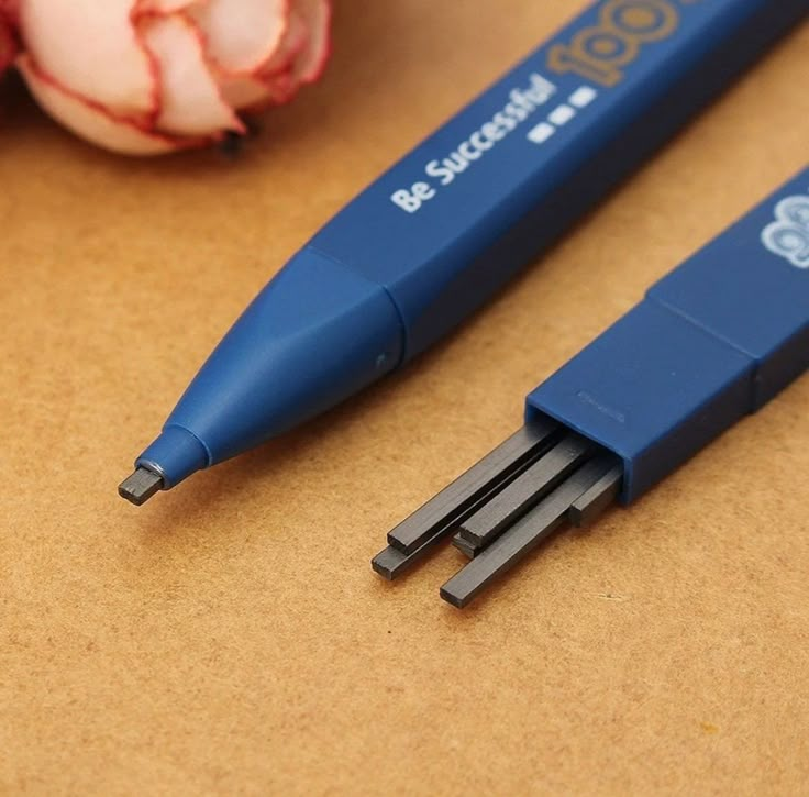 two pens sitting on top of a table next to an onion and some garlics