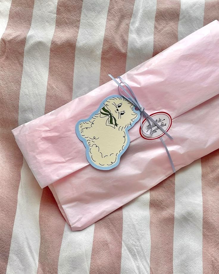 a pink and white striped blanket with a small sticker on the top of it