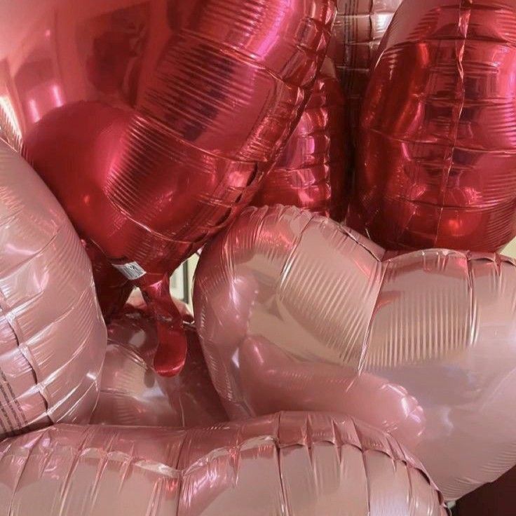 pink foil balloons are stacked on top of each other in the shape of heart shapes