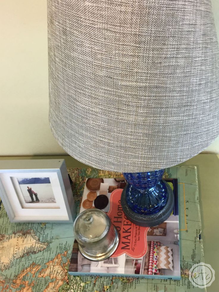 a lamp sitting on top of a table next to pictures