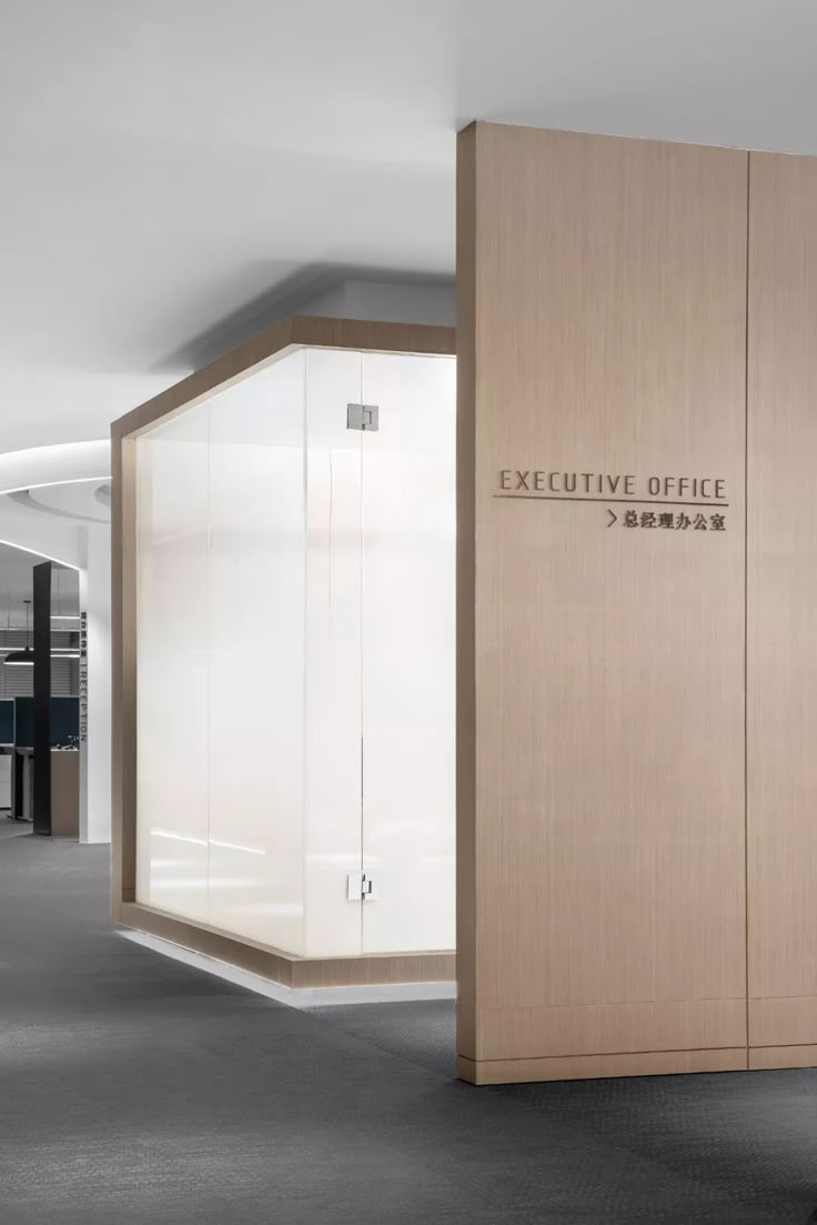 an executive office with glass walls and wood paneling