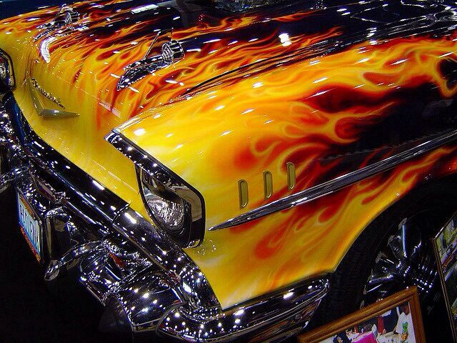 an orange and yellow car with flames on it