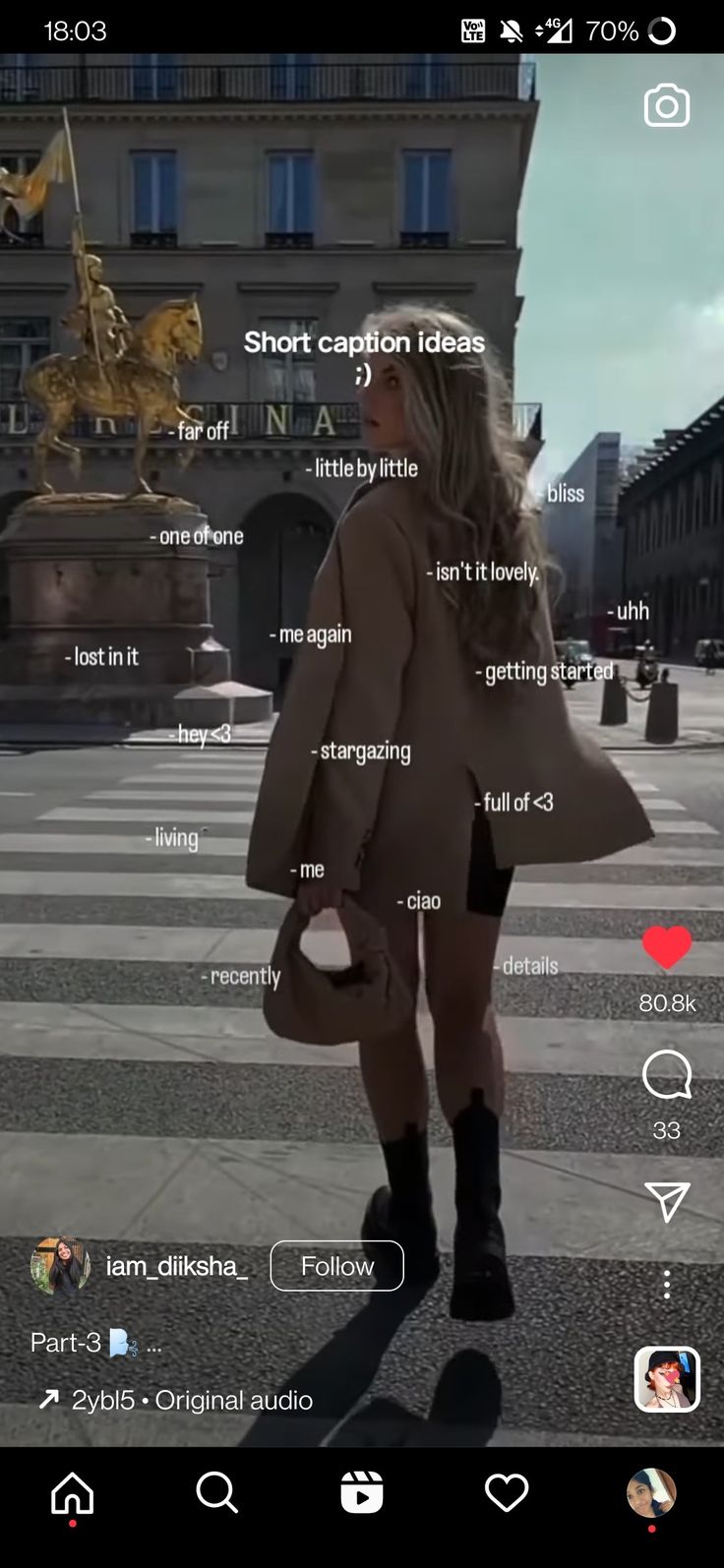 a woman walking across a street next to tall buildings