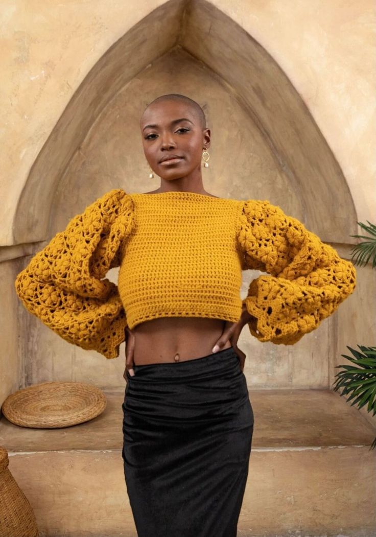 a woman wearing a yellow sweater and black skirt