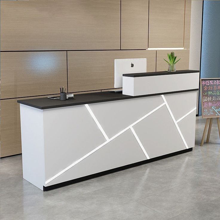 an office reception area with white and black counter tops, two planters on each side