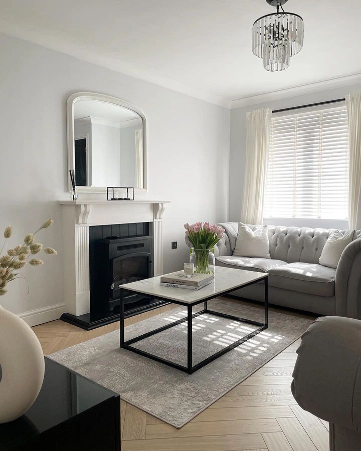 a living room filled with furniture and a fire place in front of a mirror on the wall