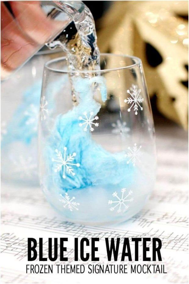 blue ice water is being poured into a wine glass with snowflakes on it