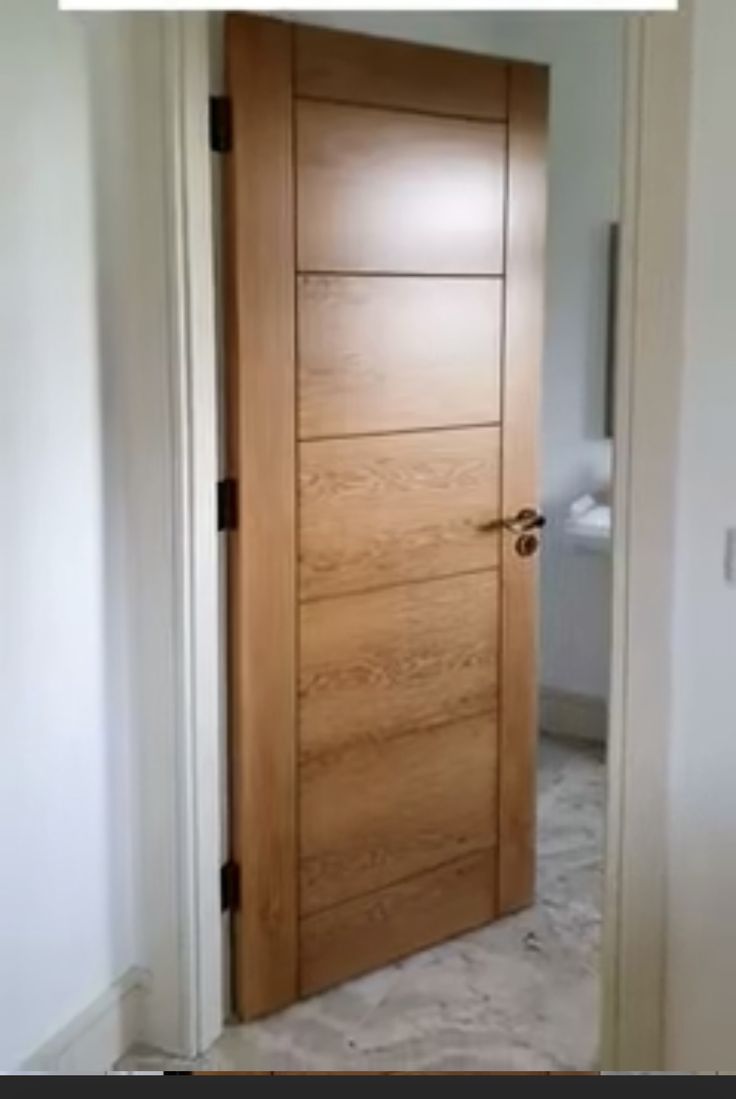 an open wooden door in a white room