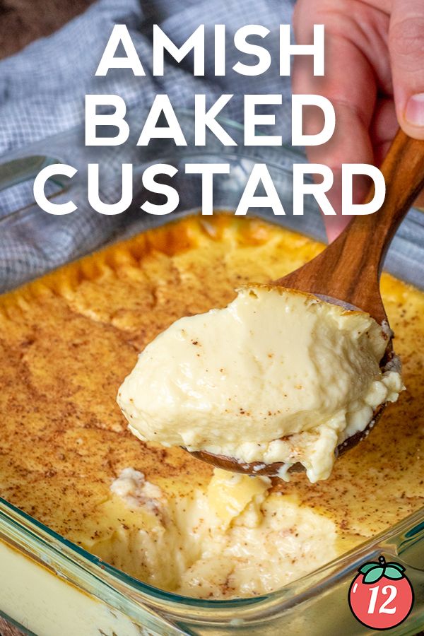 a hand holding a wooden spoon over a baked custard in a glass casserole dish