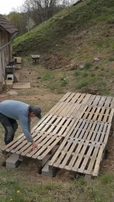 a man is working on some wooden pallets