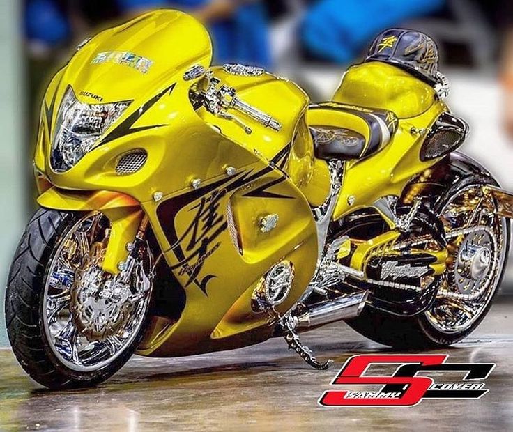 a yellow motorcycle parked on top of a wooden floor