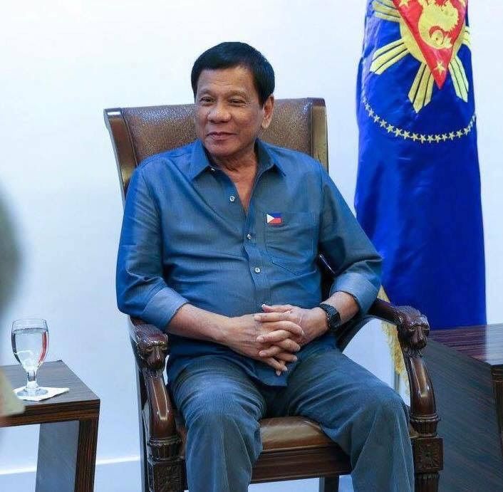 a man sitting in a chair with his hands folded