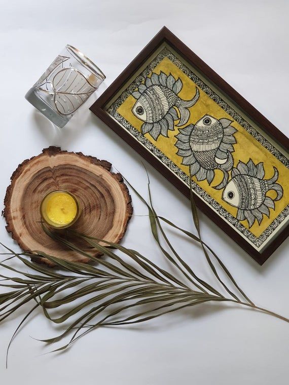 a wooden slice with some yellow liquid in it next to a glass on the table