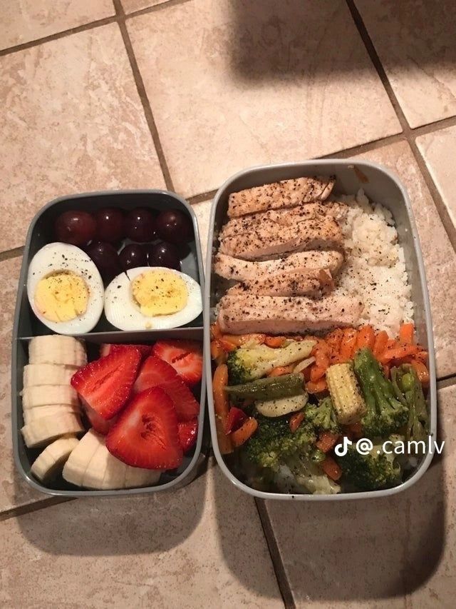 two plastic containers filled with food on top of a tiled floor next to each other