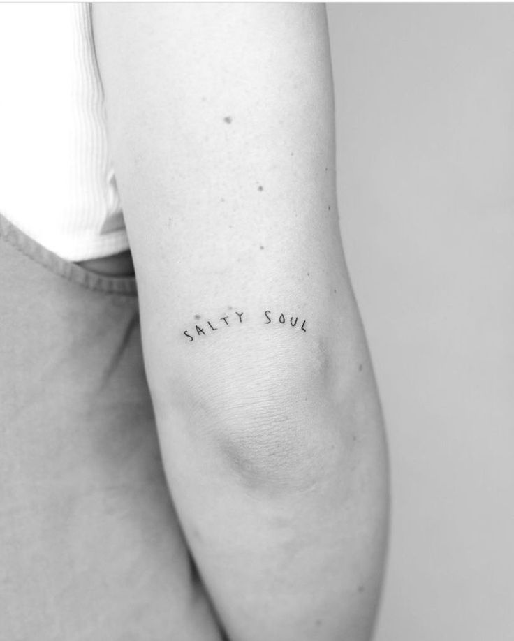 a woman's arm with the word salty soul written on it in cursive font