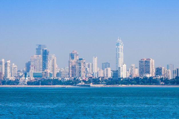 the city skyline is seen from across the water in front of blue skies and tall buildings