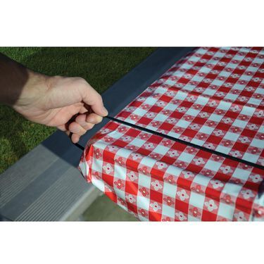 a person cutting up a red and white checkered table cloth