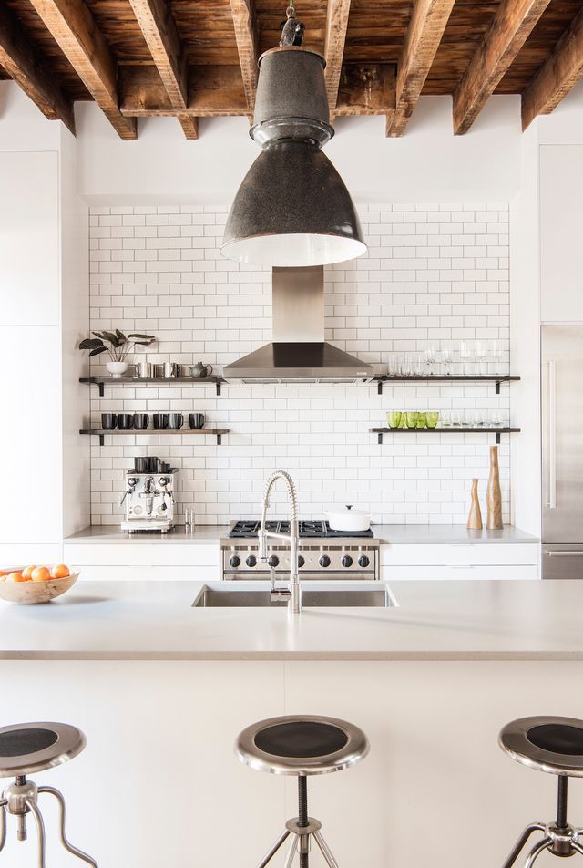 a kitchen with three stools and an island