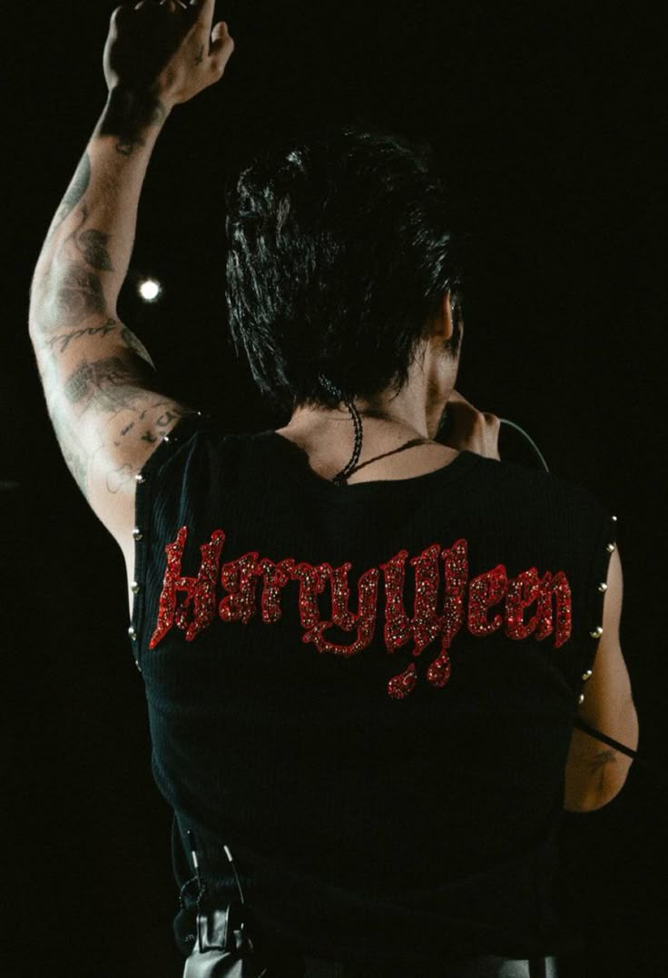 the back of a woman's black shirt with red lettering on it