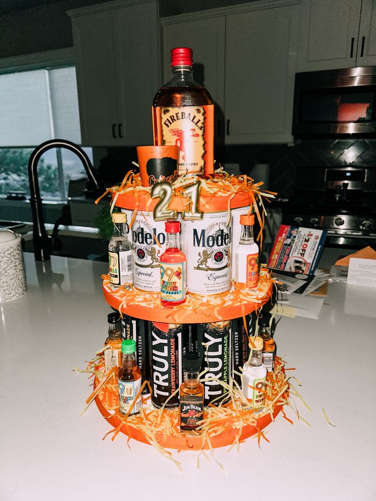 a three tiered cake made out of liquor bottles and hay on the counter top