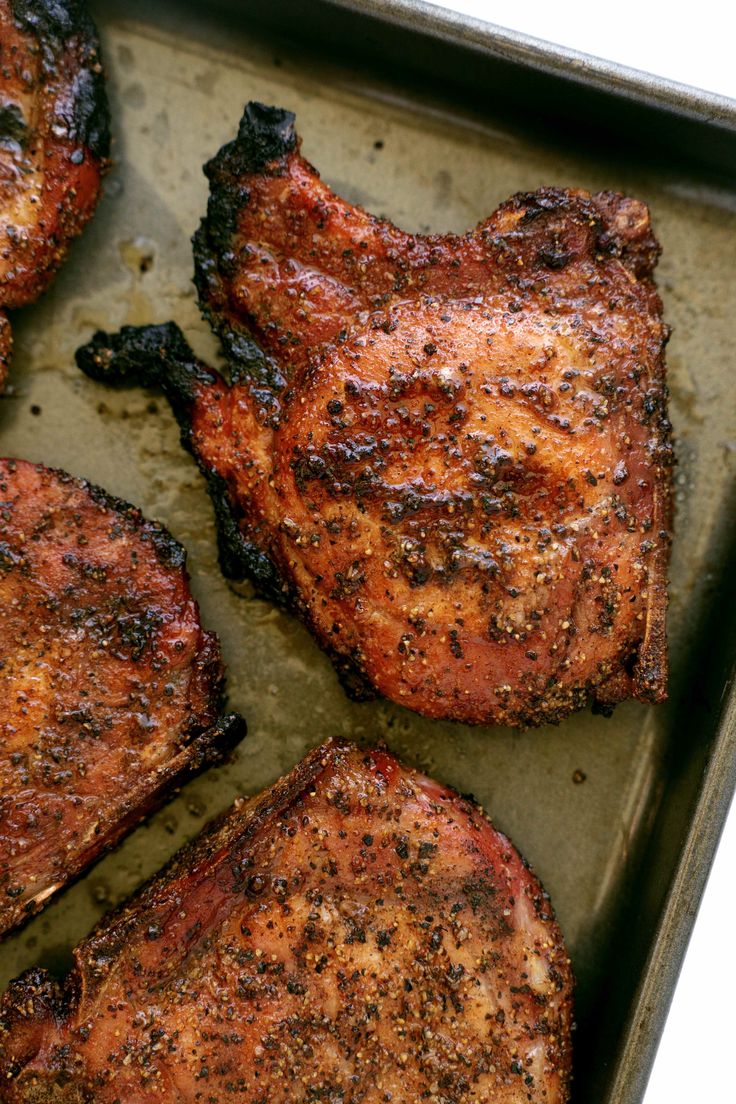 four pieces of meat sitting on top of a pan