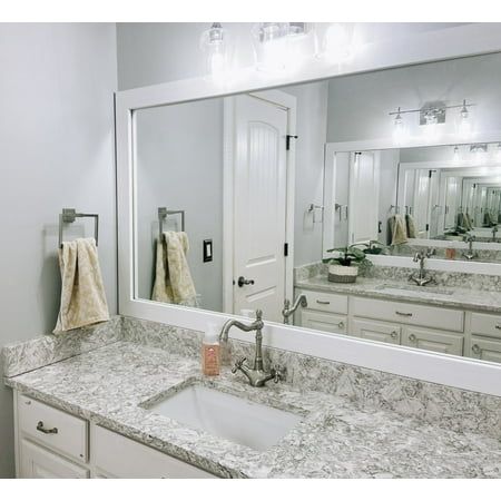 a bathroom with marble counter tops and large mirrors on the wall over the sink area