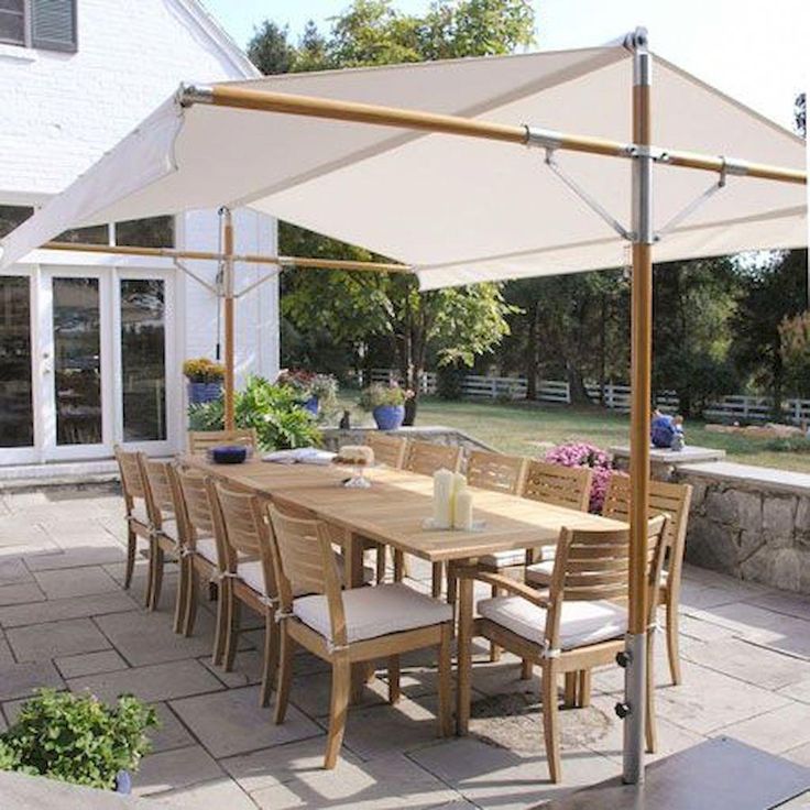 an outdoor dining table with chairs and umbrella