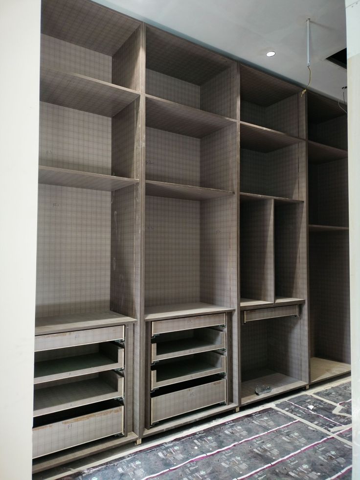 an empty room with several shelves and drawers in it, all lined up against the wall