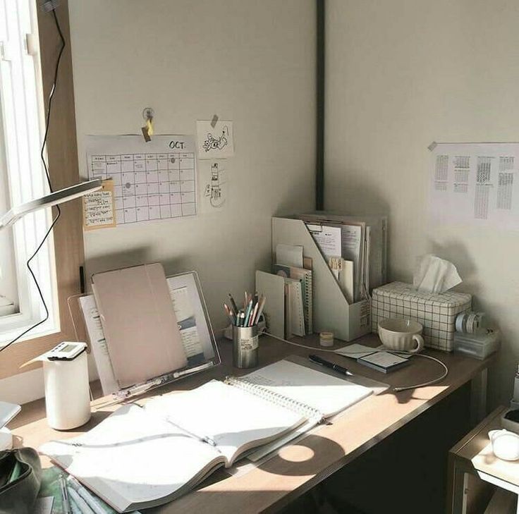 a desk with a laptop computer on top of it next to a lamp and other office supplies