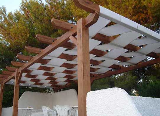 a wooden pergola with white tiles on it