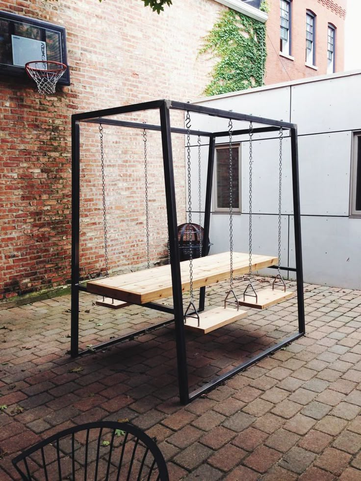 an outdoor basketball court in the middle of a brick courtyard with a bench and hoop