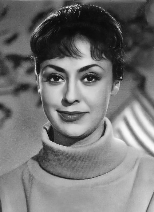 an old black and white photo of a woman with short hair wearing a turtle neck sweater