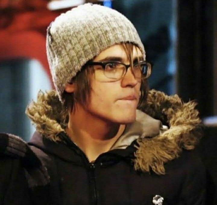 a young man wearing glasses and a knitted hat